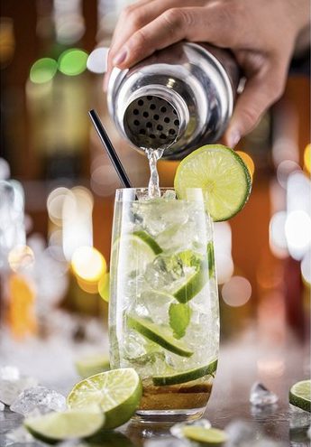 Zestaw-barmanski-do-drinkow-19 Dłoń nalewająca drinka do szklanki.